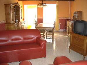 a living room with a leather couch and a television at Chez clÉmentine in Antheny