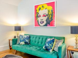 a green couch in a living room with a painting at Forest View Barn in Balcombe