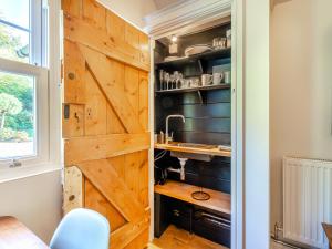 a kitchen with a wooden sliding barn door at Forest View Barn in Balcombe