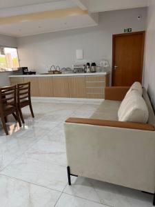 a living room with a bed and a kitchen at Hotel Marinho in Gurupi