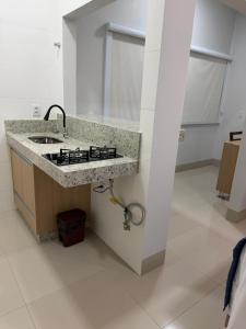 a kitchen with a sink and a stove at Hotel Marinho in Gurupi