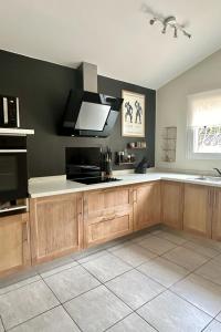 a kitchen with wooden cabinets and a black wall at Villa Tarabucetta by Interhome in Figari