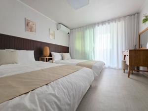 a hotel room with two beds and a window at 수원 행궁 Haru Stay in Suwon +20 photos