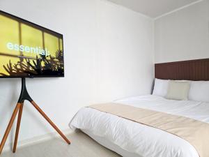 a bedroom with a bed and a tv on a wall at 수원 행궁 Haru Stay in Suwon