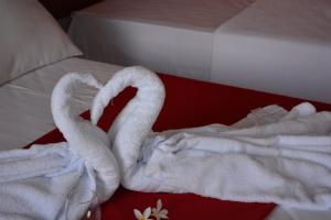dos cisnes de toalla sentados en la parte superior de una cama en Pousada Tropical, en Prado