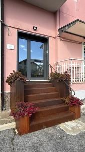 a pink building with stairs and flowers in front of a window at B&B Il Melograno in Valmontone