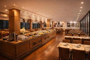a large dining room with a buffet line with tables at Hotel Thomasi Express in Maringá