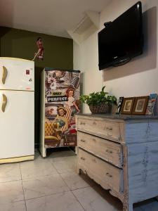 a kitchen with a refrigerator and a dresser and a tv at Pin-up hostel in Rosario