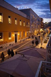 a group of people walking down a street at night at Le Gemme Rooms in Matera