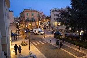 a group of people walking down a city street at night at Le Gemme Rooms in Matera
