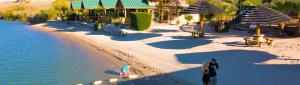 a man standing on a beach next to the water at Pirate Cove Resort in Needles +1 photo
