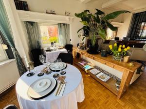 a living room with a table with plates and wine glasses at Bed & Breakfast Maison Noire Westende-bad incl parking & ontbijt in Middelkerke