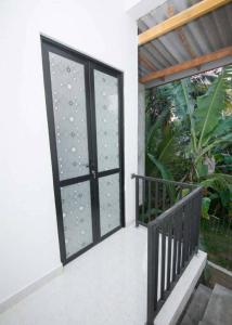 an open glass door with a black railing at City Villa Dikwella in Dickwella