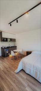 a bedroom with a bed and a table and a kitchen at GyC Laguna Resort in Chascomús