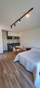 a bedroom with a bed and a table with chairs at GyC Laguna Resort in Chascomús