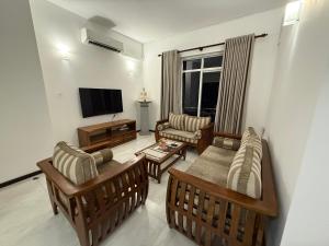 a living room with two couches and a television at Lucky Homes in Maharagama