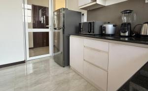 a kitchen with white cabinets and a stainless steel refrigerator at Lucky Homes in Maharagama