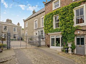 an ivycovered building with a gate in a street at 4 Bed in Middleham oc-g0189 in Middleham