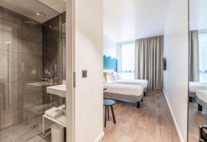 a hotel room with a bed and a bathroom at B&B HOTEL Geneva Airport in Geneva +23 photos