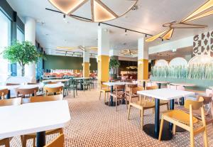 a dining room with tables and chairs in a restaurant at B&B HOTEL Geneva Airport in Geneva