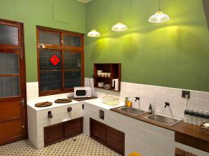 a kitchen with two sinks and a green wall at 光陰GUANGinn in Hsinchu City