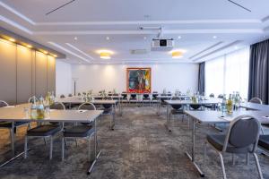 ein Konferenzraum mit Tischen und Stühlen und einem Gemälde in der Unterkunft Hotel Plaza in Duisburg