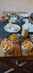 a wooden table with plates of food on it at Kithul Cottage in Nuwara Eliya +48 photos