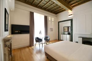a bedroom with a bed and a table and chairs at Palazzo Goldoni Condotti Collection in Rome