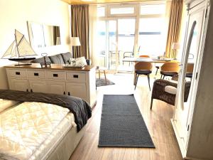 a bedroom with a bed and a desk and a table at Strandliebe-I-mit-Balkon in Burgtiefe auf Fehmarn 