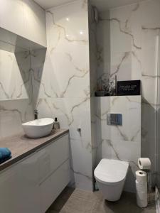 a white bathroom with a sink and a toilet at Apartament EcoPure pod Lasem Tychy in Tychy +33 photos