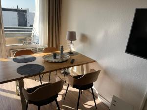 a room with a table and chairs and a window at Strandliebe-I-mit-Balkon in Burgtiefe auf Fehmarn 