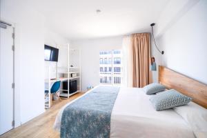 a bedroom with a large bed and a desk at Blanca by Uephotels in Can Picafort