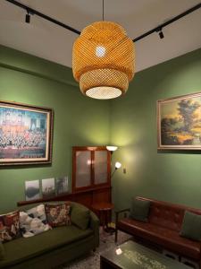 a living room with green walls and a chandelier at 光陰GUANGinn in Hsinchu City