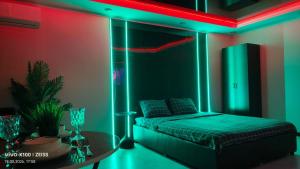 a bedroom with a bed with a green and red lighting at Астана 34 in Ustʼ-Kamenogorsk
