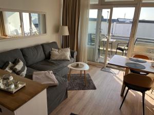 a living room with a couch and a table at Strandliebe-I-mit-Balkon in Burgtiefe auf Fehmarn 