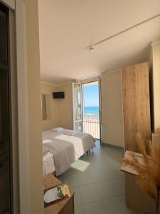 a bedroom with two beds and a view of the ocean at Hotel Gandolfo in Alassio +18 photos