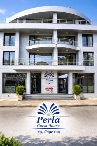 a building with a sign in front of it at Хотел PERLA in Strelcha
