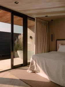 a bedroom with a bed and a sliding glass door at Haven Lake Village in Kortenhoef
