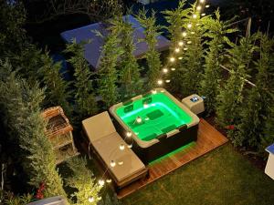 a small pool in a garden with lights at Villa Maria Apartments by BookVillaEU in Nea Kallikrateia