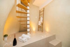 a bathroom with white towels and a spiral staircase at Aria di Mare CENTER HOME in Vieste
