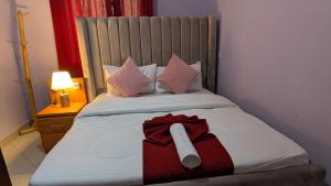 a bed with a red bow on top of it at Zion Crest Suites - Kilimanjaro Helichrysum Homes in Arusha