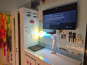 a room with a computer on a wall with a tv at Studio Lipstick in Saly Portudal
