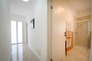a hallway with a white door and a walk in shower at Me amìa in Dolo