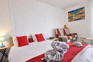 a bedroom with a white bed with red pillows at 5 Mins to Train Station - Free Parking - DisneyLand - Escapade Perchée in Pomponne