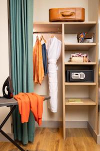 a walk in closet with a desk and clothes at Hôbou - ex Hotel Acanthe in Boulogne-Billancourt +42 photos