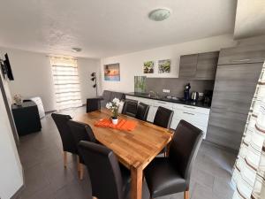 a kitchen and dining room with a wooden table and chairs at Hilda Apartments Rust in Rust