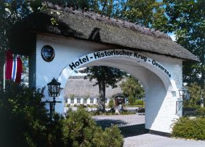a sign for a hotel hitzenhofer king center with a building at Hotel Historischer Krug in Oeversee