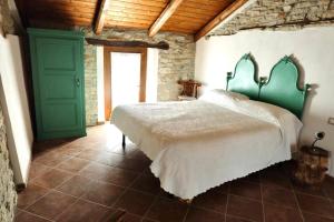 a bedroom with a large bed and a green door at BeB La Bergera in Cessole