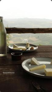 a table with two plates of cheese and a bottle of milk at BeB La Bergera in Cessole