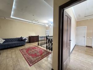 a living room with a blue couch and a rug at Meridian Hostel in Almaty